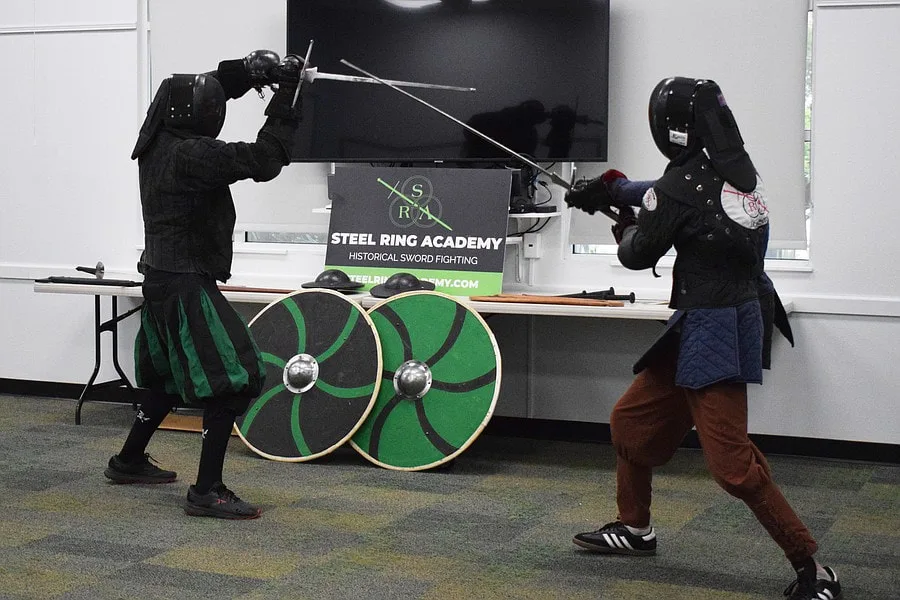 Instructor Chris and student Galloway demonstrate a longsword fight during a summer reading program demonstration.