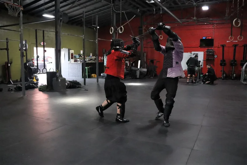 Two students mid longsword spar.