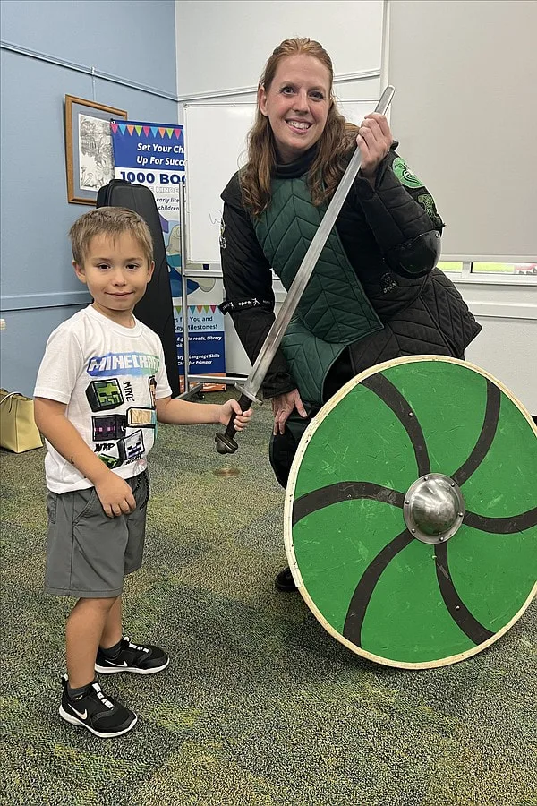Instructor Amanda at a summer reading program demonstration taking a photo with a child at the Braden River Library.