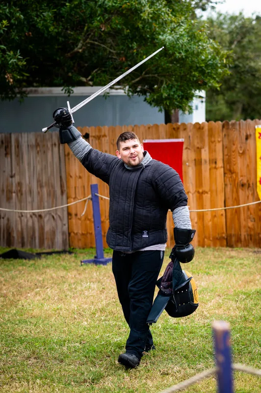 Student Brandon raises his sword in victory at the Suncoast Renaissance Festival.