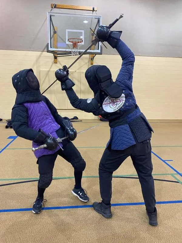 Jack demonstrates a longsword thrust with Braam.