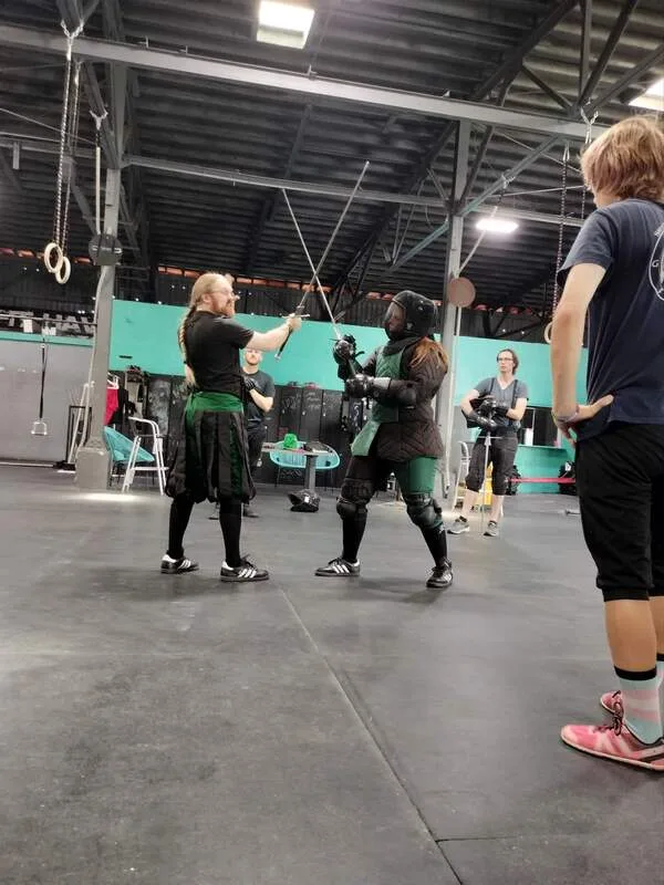 Jason and Amanda with crossed longswords during lesson.