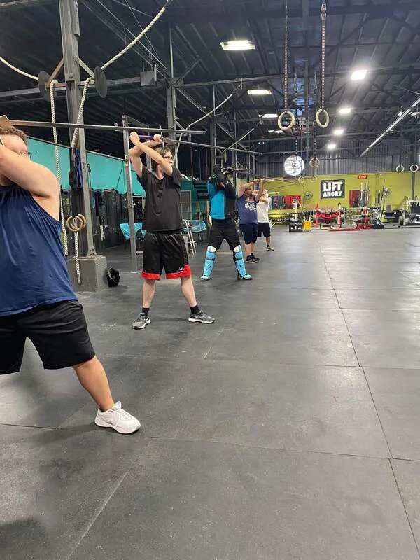 Multiple students practing longsword stances.