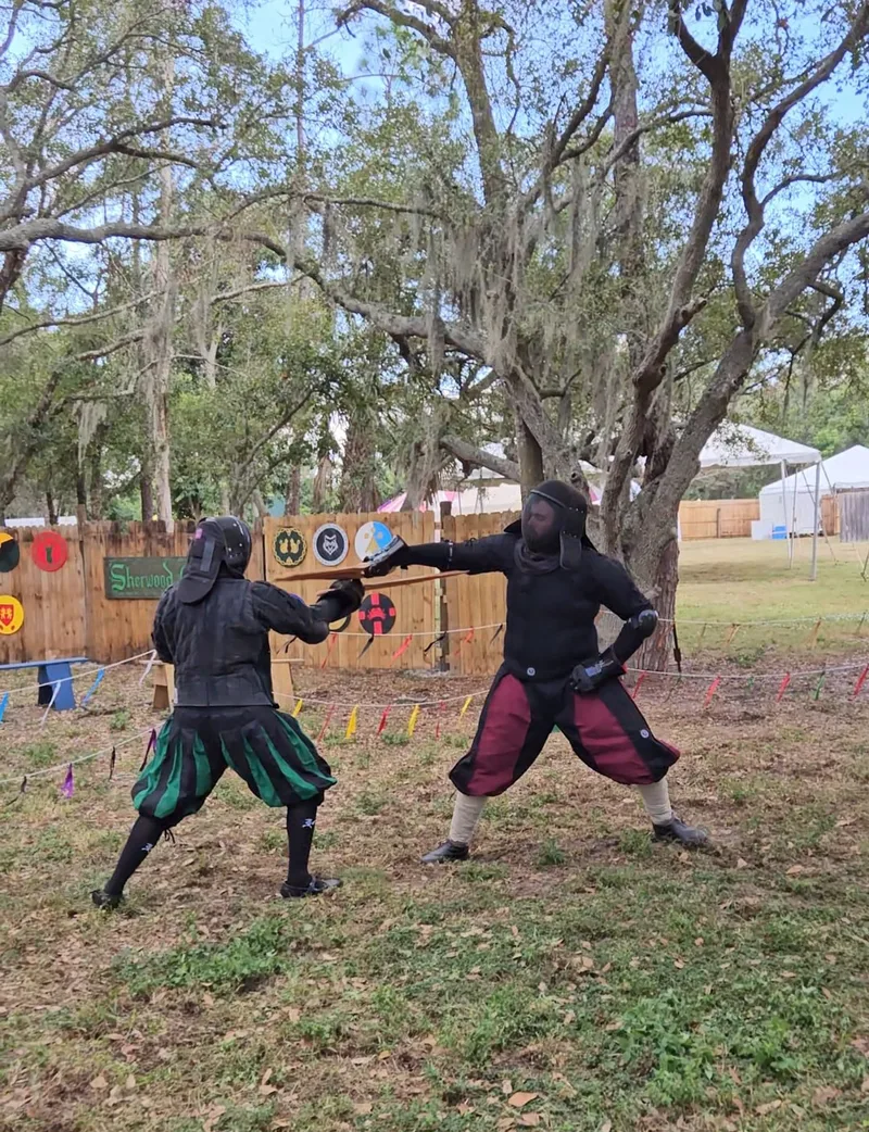 Steel Ring Academy Instructor Chris and student Avery sparring with leather dussacks at the Suncoast Renaissance Festival.