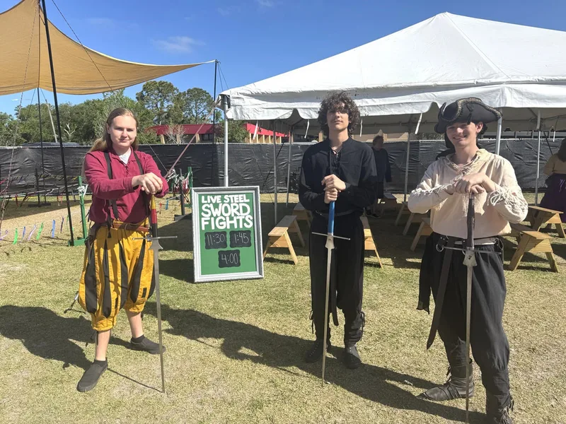 Teen students Ethan, Dominic, and Galloway promoting Demonstration times to passersby at Steel Ring Academy's Encampment.